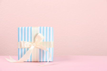 Beautiful gift box on table against color backgroundの写真素材