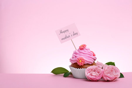 Tasty cupcake and flowers for Mother's Day on color backgroundの写真素材