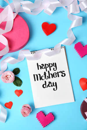 Notebook with phrase "HAPPY MOTHER'S DAY" and decor on color backgroundの写真素材