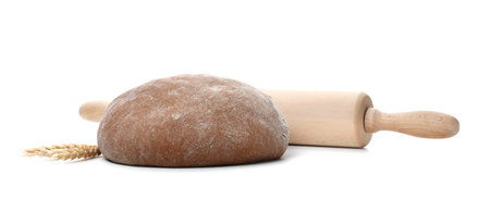 Raw rye dough, rolling pin and spikes on white backgroundの写真素材