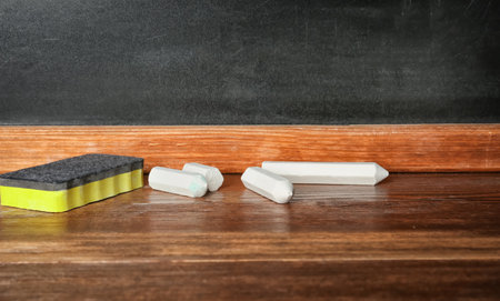 Chalk and duster on table in classroom