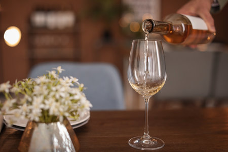 Man pouring wine into glass on tableの写真素材