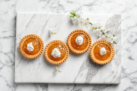 Tasty tartlets with jam on light background, top viewの写真素材
