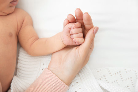 mother holding little baby handの写真素材