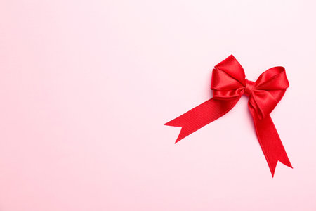 Red ribbon bow on color background, top viewの写真素材
