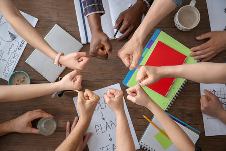People putting fists together at table, top view. unity conceptの写真素材