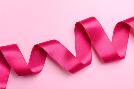 Simple pink ribbon on color background, top viewの写真素材