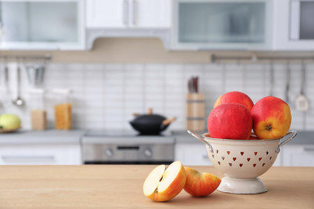 Ripe apples and blurred view of kitchen interior on backgroundの写真素材