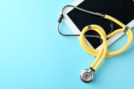 Stethoscope and tablet on color background, top view. medical equipmentの写真素材