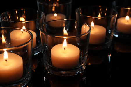 Wax candles burning on table in darkness, closeupの写真素材