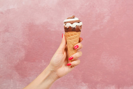 Woman holding yummy ice cream on color background. focus on hand