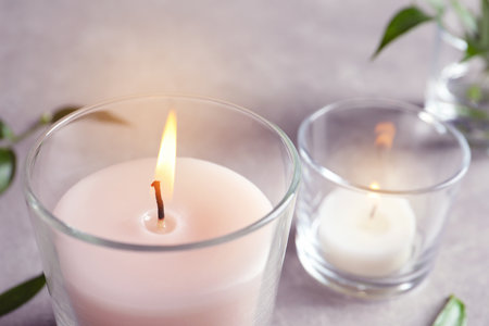 Burning wax candle in glass on table, closeupの写真素材