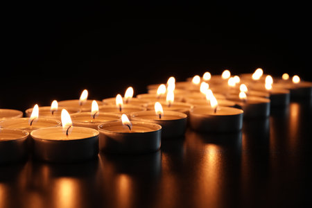 Wax candles burning on table in darkness, closeupの写真素材