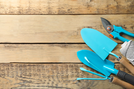 Flat lay composition with professional gardening tools on wooden backgroundの写真素材