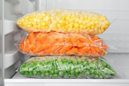 Plastic bags with deep frozen vegetables in refrigeratorの写真素材