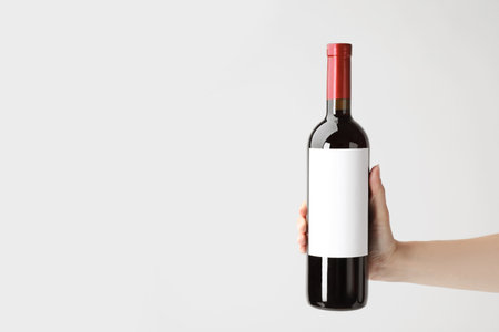 Woman holding bottle with delicious wine on white backgroundの写真素材