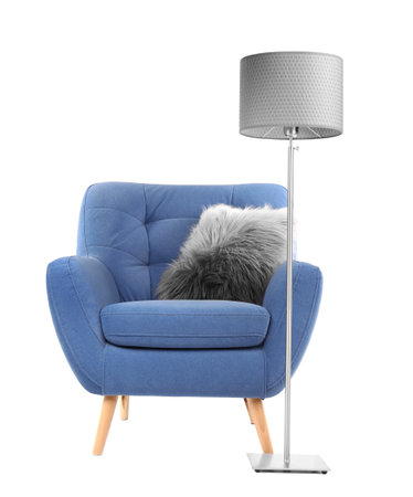 Comfortable armchair with pillow and lamp on white backgroundの写真素材