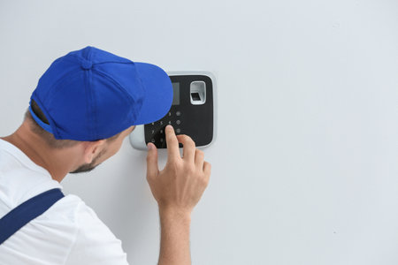 Young male technician programming alarm system indoorsの写真素材