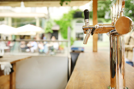 Bar counter with draft beer taps in open-air cafeの写真素材