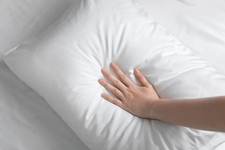 Young woman touching soft white pillow, closeupの写真素材