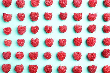 Flat lay composition with ripe aromatic raspberries on color backgroundの写真素材