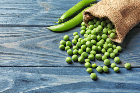Sackcloth bag with fresh green peas on wooden backgroundの写真素材
