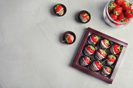 Flat lay composition with chocolate-covered strawberries on gray backgroundの写真素材