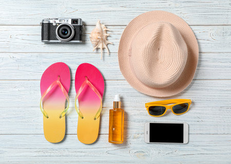 Flat lay composition with beach objects and mobile phone on wooden backgroundの写真素材