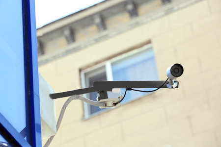 Modern security CCTV camera on wall outdoorsの写真素材