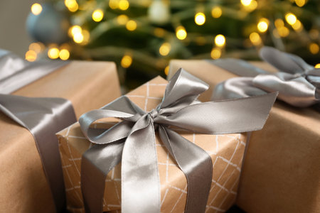Beautiful gift boxes and blurred Christmas tree on background