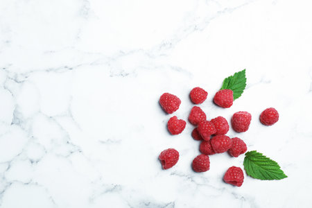 Ripe aromatic raspberries on marble table, top viewの写真素材