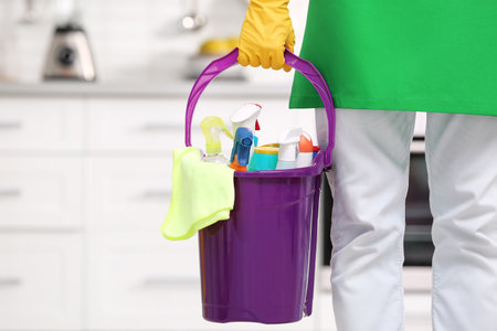 Man in uniform with cleaning supplies indoorsの写真素材