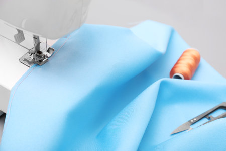 Sewing machine with fabric on table in tailor workshop, closeupの写真素材