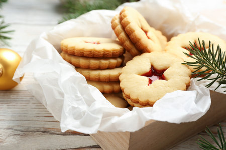 Traditional Christmas Linzer cookies with sweet jam in wooden crate on tableの写真素材