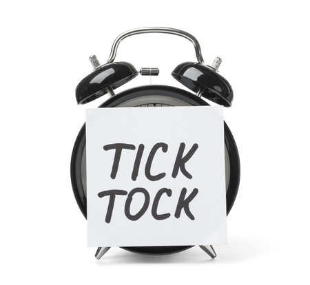 Alarm clock and sticky note with words TICK TOCK on white background. time conceptの写真素材