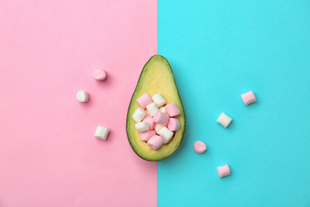 Composition with ripe avocado and marshmallows on color background, top view