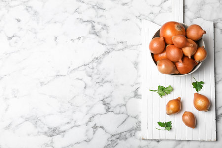 Flat lay composition with fresh ripe onions on marble tableの写真素材