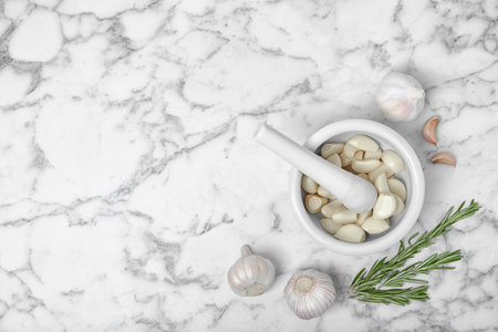 Flat lay composition with garlic and mortar on marble backgroundの写真素材