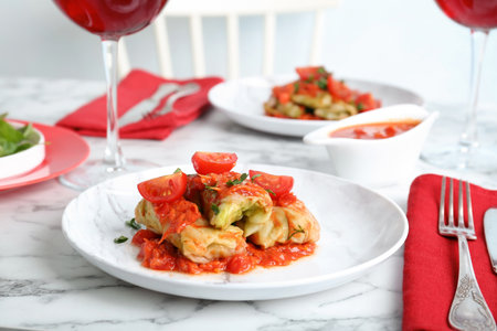 Plate with stuffed cabbage leaves in tomato sauce on tableの写真素材