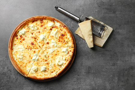 Tasty hot pizza, cheese and grater on gray background, top viewの写真素材