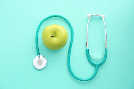 Flat lay composition with stethoscope and apple on color backgroundの写真素材