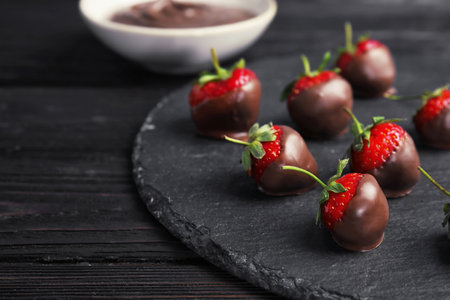 Slate plate with chocolate covered strawberries on table, closeupの写真素材