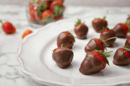 Plate with chocolate covered strawberries on table, closeupの写真素材