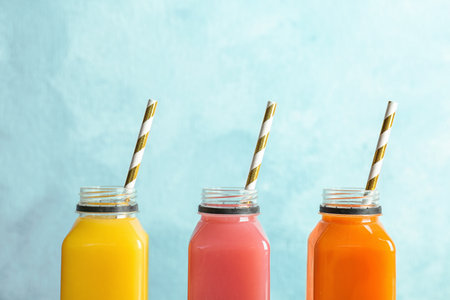 Bottles with tasty juices on color backgroundの写真素材