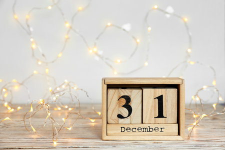 Wooden block calendar and electric garland on table. christmas count down