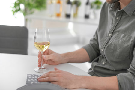 Young man with glass of wine indoorsの写真素材