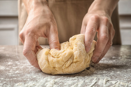 Woman kneading dough for pasta at tableの写真素材