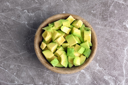 Bowl with cut avocado on gray background, top viewの写真素材