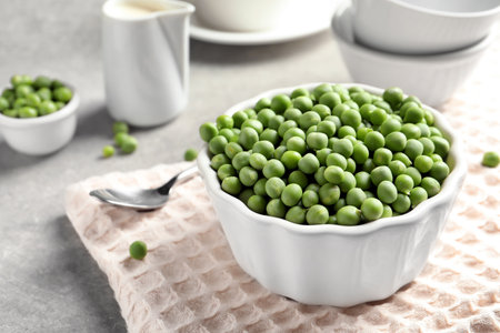 Bowl with delicious fresh green peas on tableの写真素材