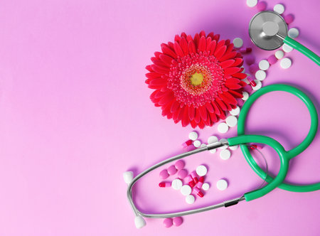 Flat lay composition with stethoscope, flower and pills on color background. Gynecological checkupの写真素材